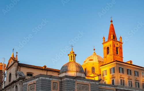Rome Italy. The church of "Santa Maria del Popolo" in the square of the same name, with a view of the bell tower and the side lined with thick travertine slabs. © AdryPhoto