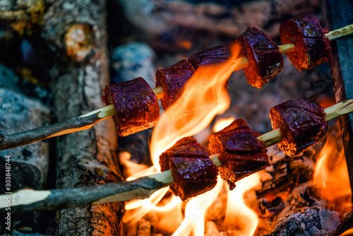 Sausage on a stick roasted over a camping fire