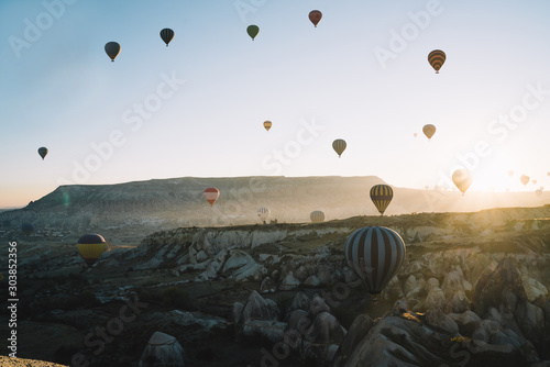 Colorful air balloons racing over highlands at sunrise