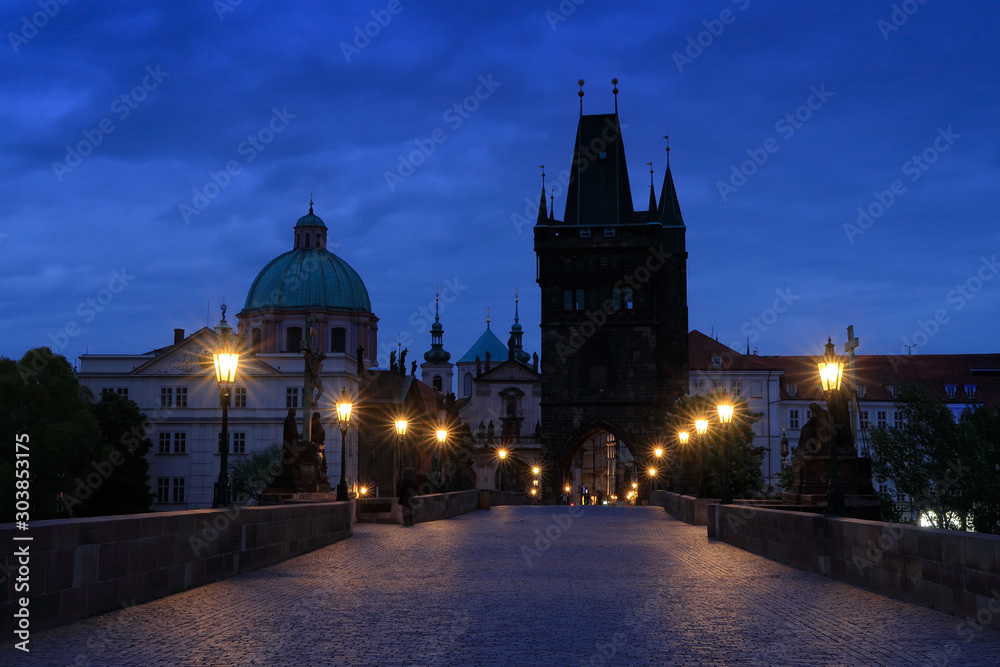 Naklejka premium Prague, Charles Bridge in night. Lights on the bridge, built in medieval times. Twilight view of Prague with blue sky. Travelling in Europe. Town Prague, capital of Czech Republic, old city.
