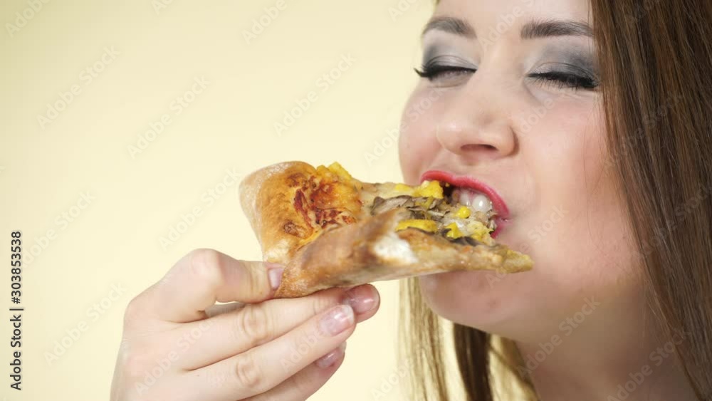 Young woman eating hot fresh pizza, on yellow background. Delicious fast food meal. People, italian cuisine concept Young woman eating hot fresh pizza, on yellow background. Delicious fast food meal. People, italian cuisine concept