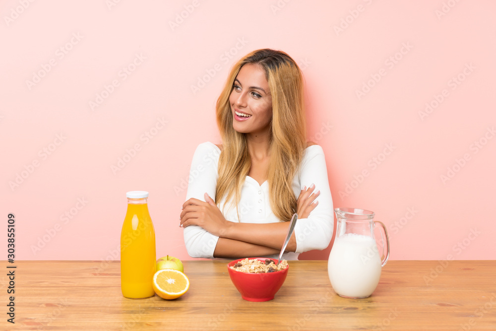 Young blonde woman having breakfast milk looking to the side Young blonde woman having breakfast milk looking to the side