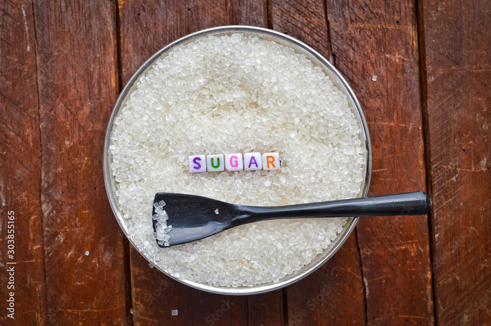 Written in letter sugar,writing a sugar with black spoon and Brown wooden background,brown background on sugar, Written in letter sugar,writing a sugar with black spoon and Brown wooden background,brown background on sugar,
