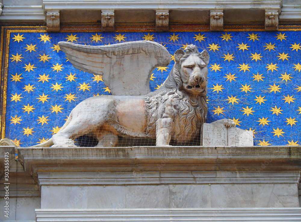 View of the lion sculpture in the exterior of the Saint Mark's Clock Tower (Torre dell'Orologio) in Venice, Italy. The lion is the symbol of the city of Venice.
