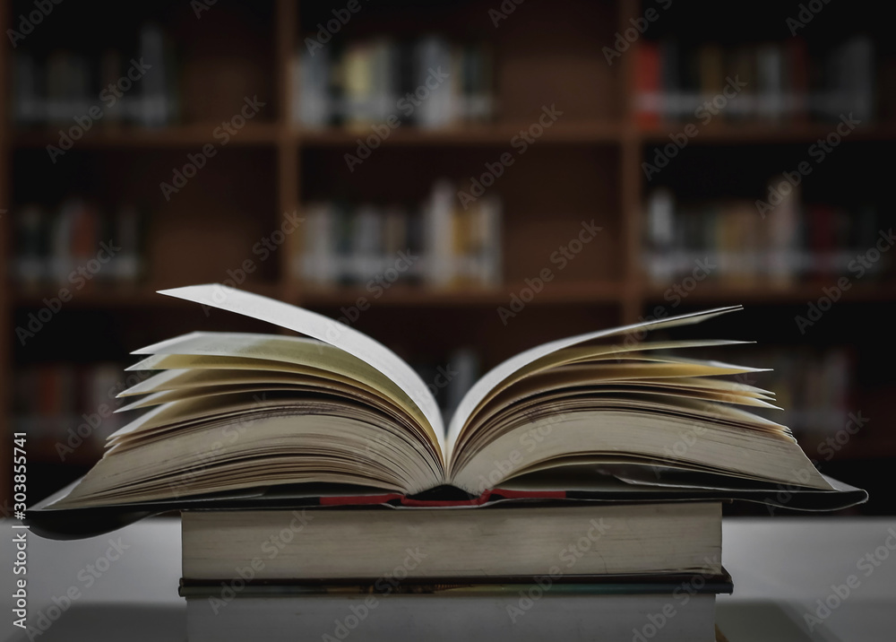 Stack of books in the library and blur bookshelf background Stack of books in the library and blur bookshelf background