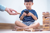 Asian children in the age of social networks that focus on phones or tablets. Do not care about the surrounding environment and have eye problems. video game-addicted children concept