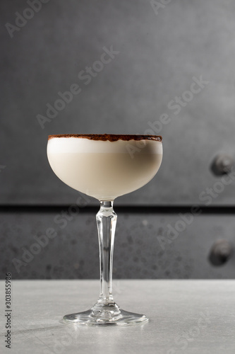 Glasses of Irish cream liqueur with anise, cocoa and ice on gray background. Selective focus. Overhead view, copy space. Advertising for cafe. Bar menu. Vertical photo.