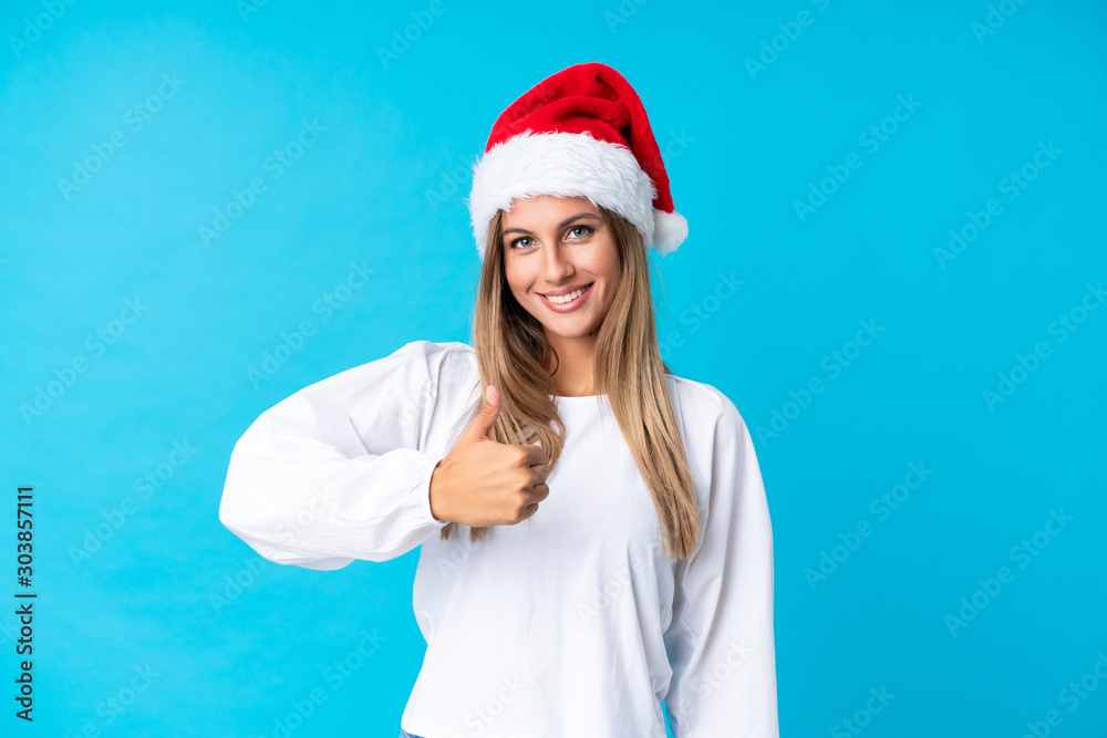 Girl with christmas hat over isolated background giving a thumbs up gesture Girl with christmas hat over isolated background giving a thumbs up gesture