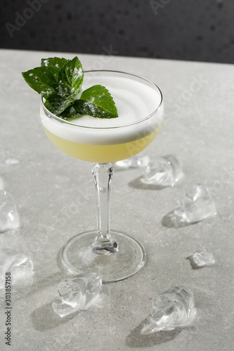 Obraz na płótnie Homemade Pisco sour cocktail. Whiskey Sour in Coupe Glass with ice on gray background. Overhead view, copy space. Advertising for cafe. Bar menu. Vertical photo. w salonie