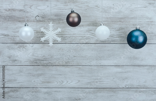 Christmas baubles hanging over wooden white wall. New Year and Christmas background concept. Copy space, ball, snowflake