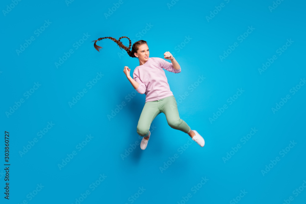Full size profile side photo of serious youngster girl have fighting battle jump kick legs fists enemy want win wear pink pullover white youth sneakers isolated over blue color background