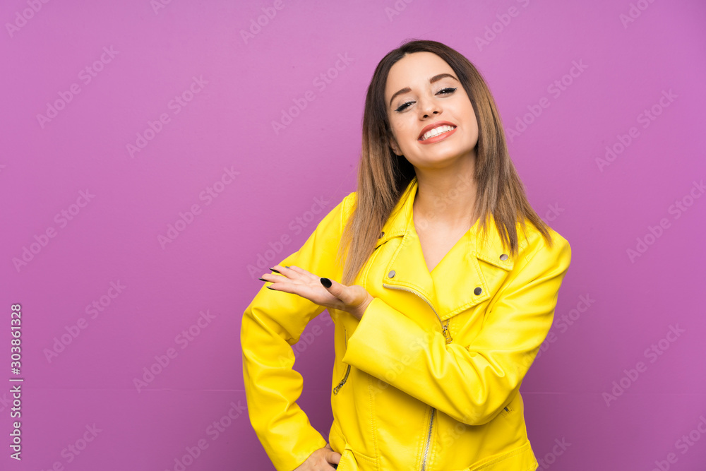 Young woman over purple background extending hands to the side for inviting to come Young woman over purple background extending hands to the side for inviting to come