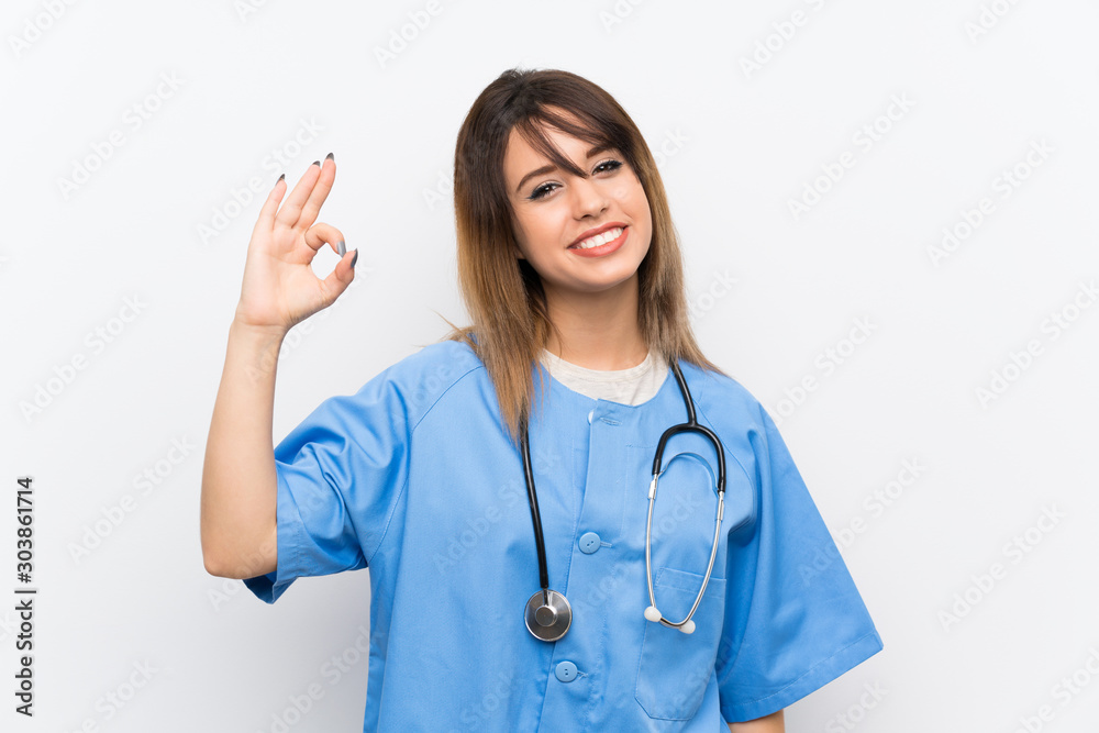 Young nurse woman over white wall showing ok sign with fingers Young nurse woman over white wall showing ok sign with fingers