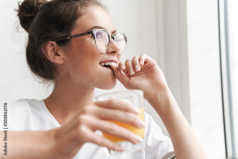 Image closeup of smiling nice woman dreaming and drinking juice Image closeup of smiling nice woman dreaming and drinking juice