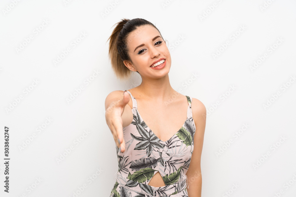 Young woman over isolated white background handshaking after good deal Young woman over isolated white background handshaking after good deal