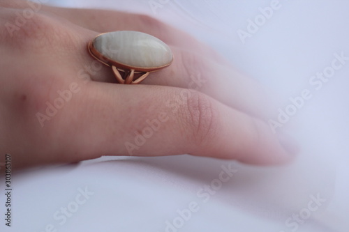 Closeup of a gold ring with white scolecite gemstone. photo