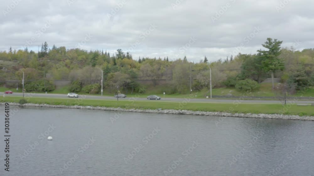 Flying above Lake of the Woods near Kenora, Ontario, Canada. Following a car passing on Trans-Canada Highway in the left. 4d drone footage from left to right. Flying above Lake of the Woods near Kenora, Ontario, Canada. Following a car passing on Trans-Canada Highway in the left. 4d drone footage from left to right.