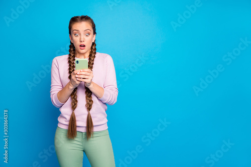 Followers dislike blog post. Portrait of frustrated emotional youth crazy girl look speechless her smartphone got horrible social media sms wear green pants trousers isolated bright color background