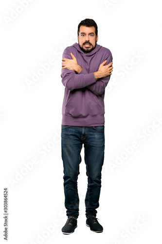 Full-length shot of Handsome man with sweatshirt freezing over isolated white background