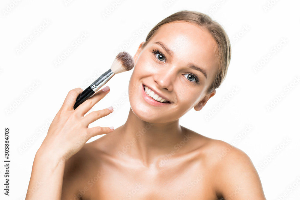 Beautiful young woman applying loose face powder with brush isolated over white background. Copy space. Beautiful young woman applying loose face powder with brush isolated over white background. Copy space.