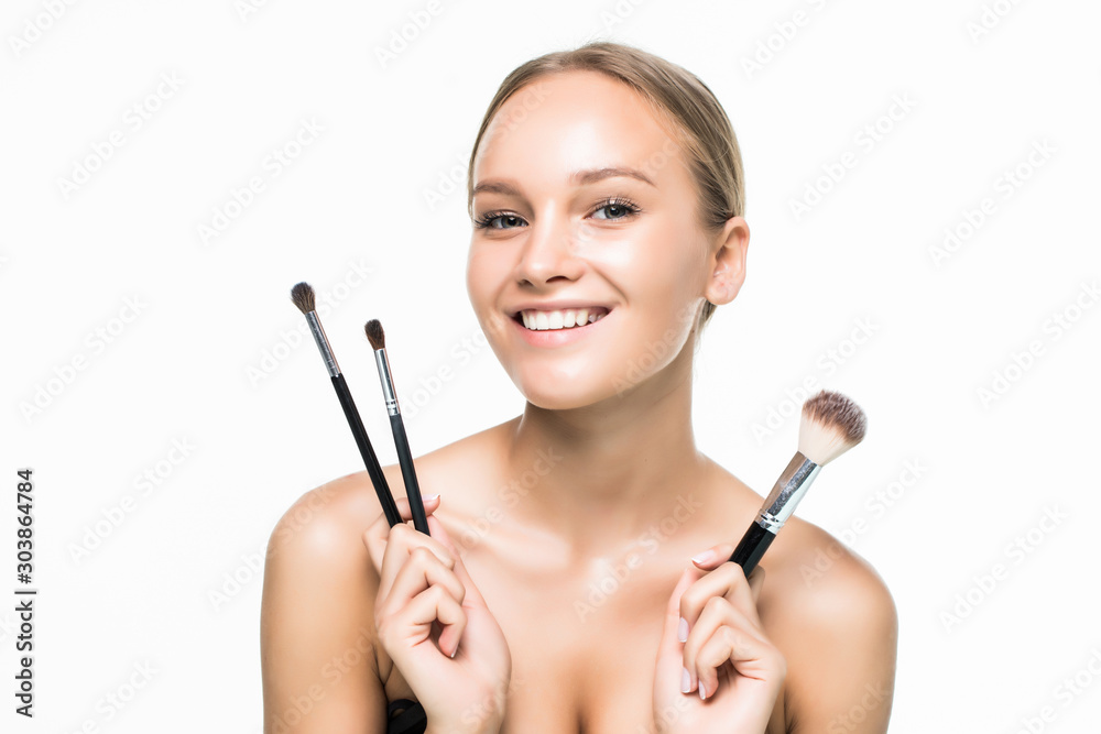 Portrait of the beautiful woman with make-up brushes near attractive face over white background Portrait of the beautiful woman with make-up brushes near attractive face over white background