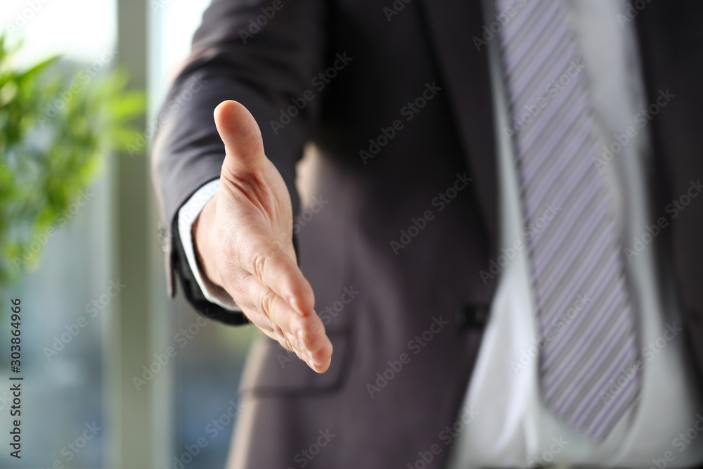 Fototapeta premium Man in suit and tie give hand as hello in office
