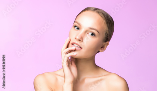 Woman body skin care. Beautiful young female touching smooth soft skin on pink background. Spa and cosmetics concept.