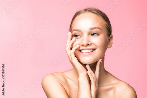 Woman body skin care. Beautiful young female touching smooth soft skin on pink background. Spa and cosmetics concept.