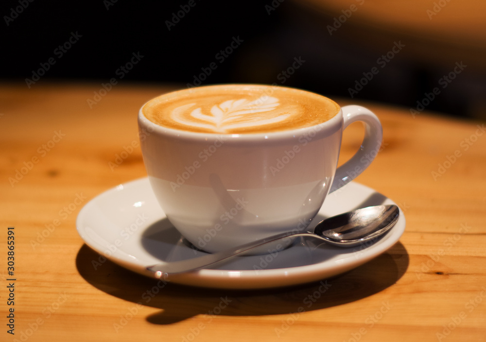 Ceramic cup in coffee shop with cappuccino on wooden empty table. Latte art. Morning drink. Caffeine. Ceramic cup in coffee shop with cappuccino on wooden empty table. Latte art. Morning drink. Caffeine.
