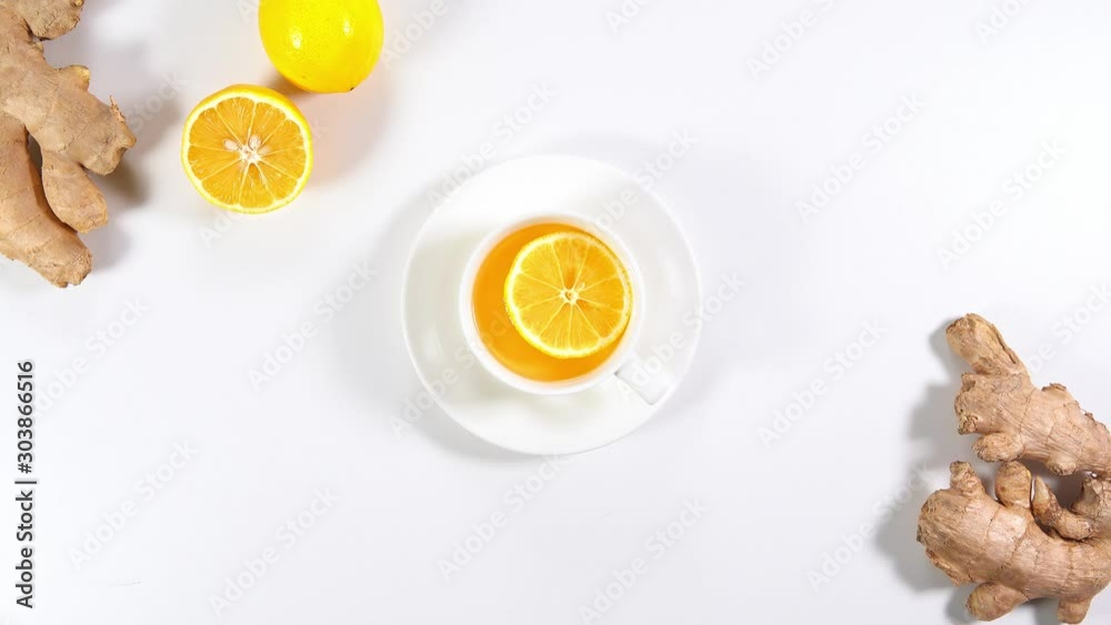 Hand puts hot ginger tea with lemon on the table. Healthy ginger and lemon tea for colds. Top view, flat lay. Hot drinks. Cup of tea. Hand puts hot ginger tea with lemon on the table. Healthy ginger and lemon tea for colds. Top view, flat lay. Hot drinks. Cup of tea.