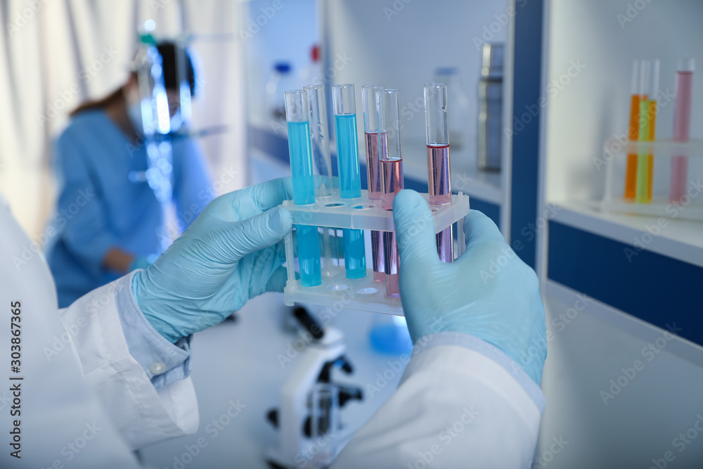 Scientist holding test tubes with liquid indoors, closeup. Laboratory analysis Scientist holding test tubes with liquid indoors, closeup. Laboratory analysis