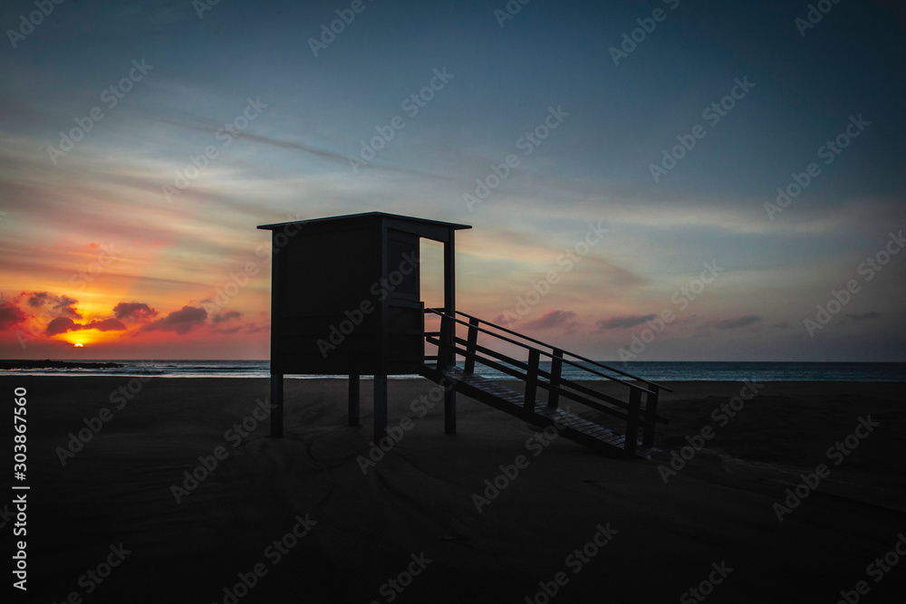 beach hut at sunrise on playa blanca beach, puerto del carmen, lanzarote.
