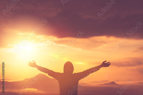 Copy space of man rise hand up on top of mountain and sunset sky abstract background.