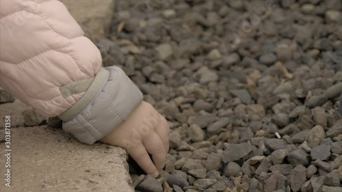 Close up of a lillte girl hands while playing with rocks three photo