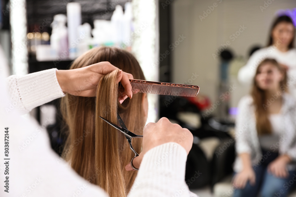 Φωτογραφία Hairdresser making stylish haircut with professional scissors in salon, closeup