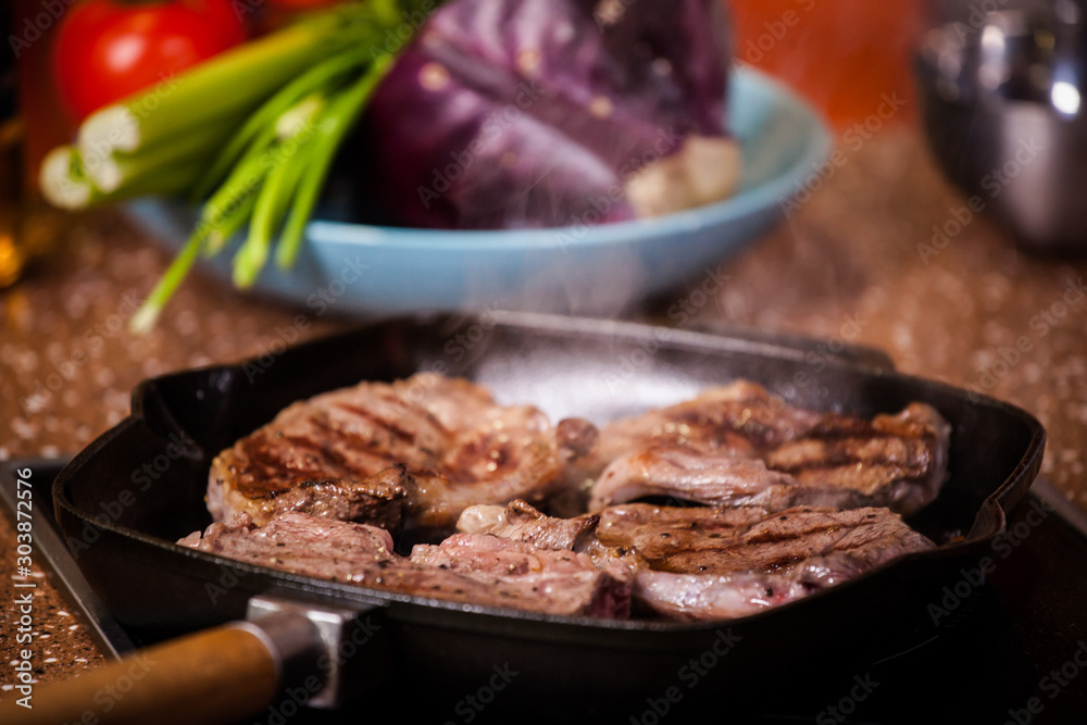 grilled steak in a frying pan on a background of vegetables grilled steak in a frying pan on a background of vegetables