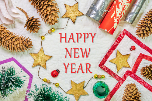 Vászonkép Happy New Year - Winter composition with spruce cones, wrapping paper, star string, and ribbons, on white background with geometric shaped frames