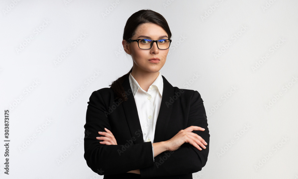 Business Girl Standing Looking At Camera Crossing Hands, Studio Shot Business Girl Standing Looking At Camera Crossing Hands, Studio Shot