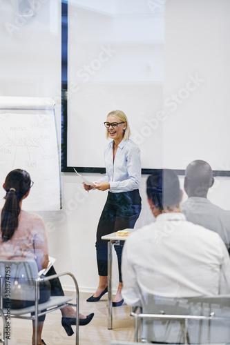 Young manager laughing while giving an office presentation