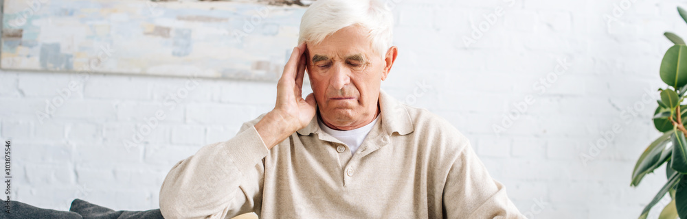 panoramic shot of senior man having headache in apartment panoramic shot of senior man having headache in apartment