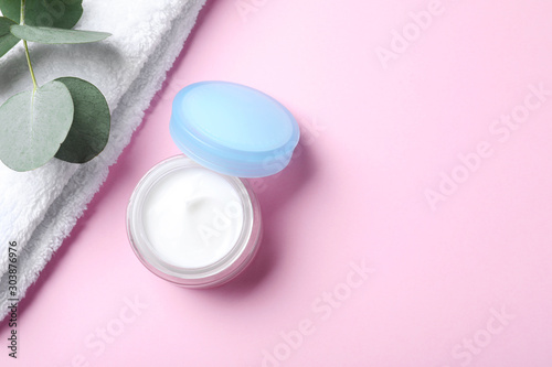 Open jar of cream on pink background, flat lay. Space for text