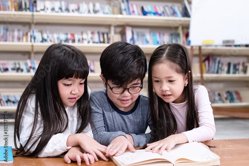Group of children reading book,with interested feeling,at library,blurry light around