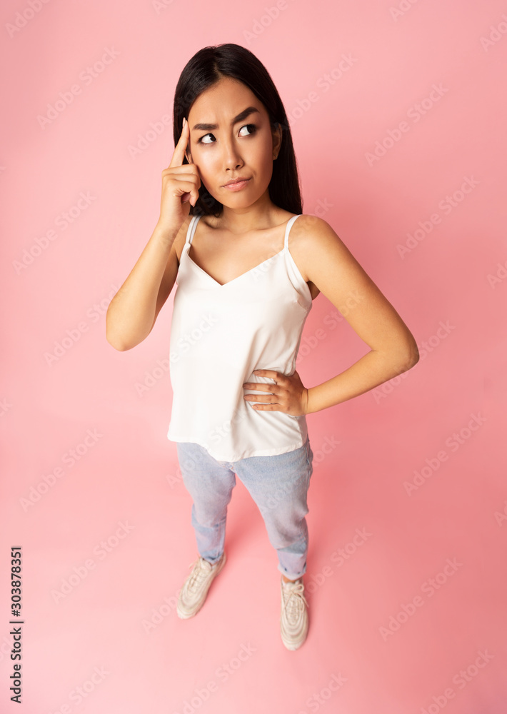Thoughtful girl holding finger on temple, high angle view Thoughtful girl holding finger on temple, high angle view