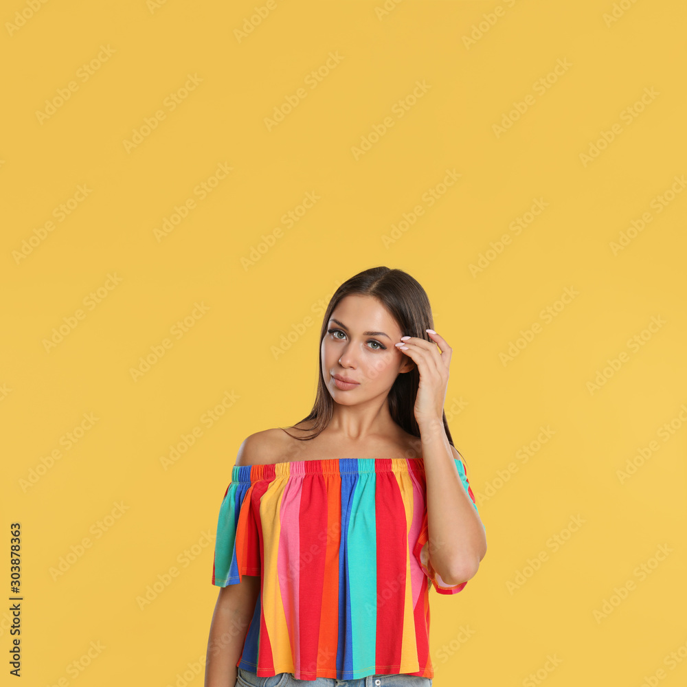 Portrait of beautiful young woman on yellow background Portrait of beautiful young woman on yellow background