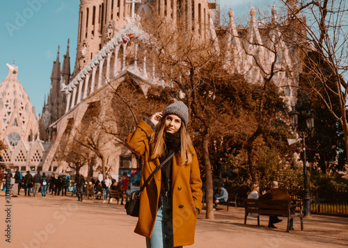 Sagrada Familia, Barcelona. Spain. Date 19/01/2019. The girl in a mustard coat on the background of the sights of Barcelona. 