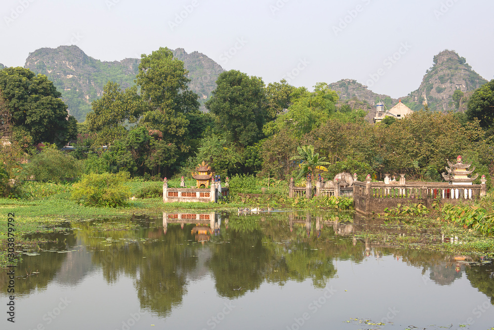  Typical colorful Vietnamese tomb in a pond, of Tam Coc, a part of Trang An Complex  a UNESCO World Heritage Natural and Cultural Monument.Ninh Binh , Vietnam