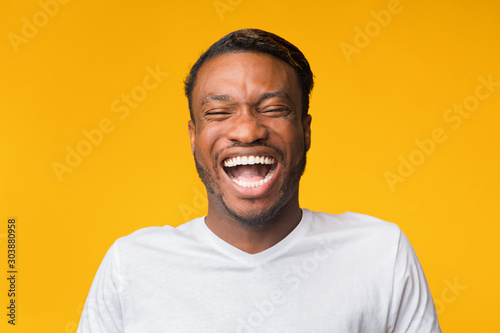 Konstfotografi Portrait Of Laughing Black Man Standing Over Yellow Background, Studio