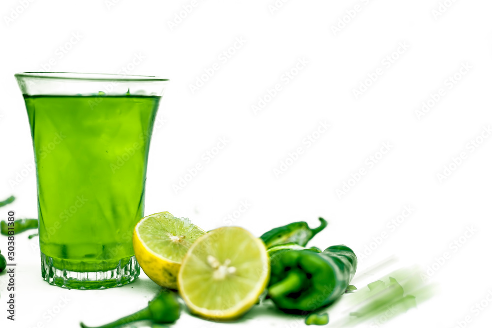 Φωτογραφία Close up shot of raw cut chilies with some sliced lemons isolated on white along with its chili flavored drink with it in a glass