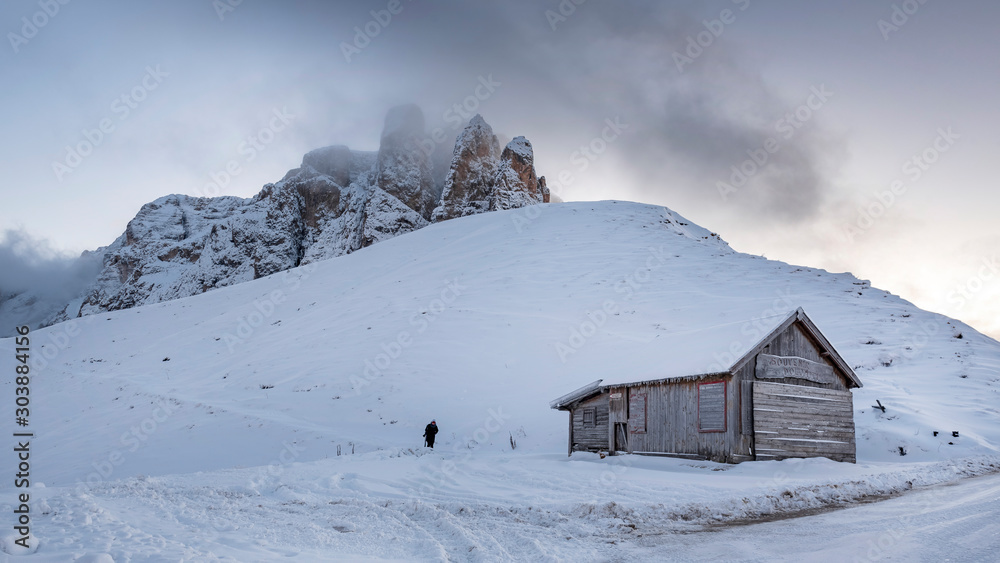 Wooden cabin with dolomite mountains in Alps ,South Tyrol, Italy - Deep snow during sunny winter day Wooden cabin with dolomite mountains in Alps ,South Tyrol, Italy - Deep snow during sunny winter day