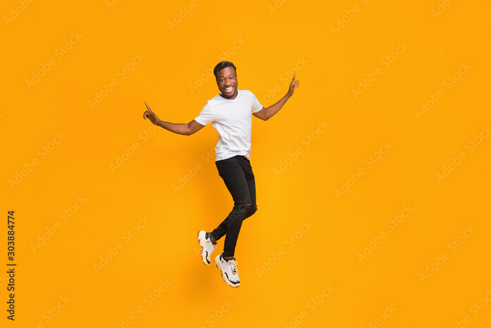 Joyful Afro Guy Jumping In Air Having Fun, Studio Shot
